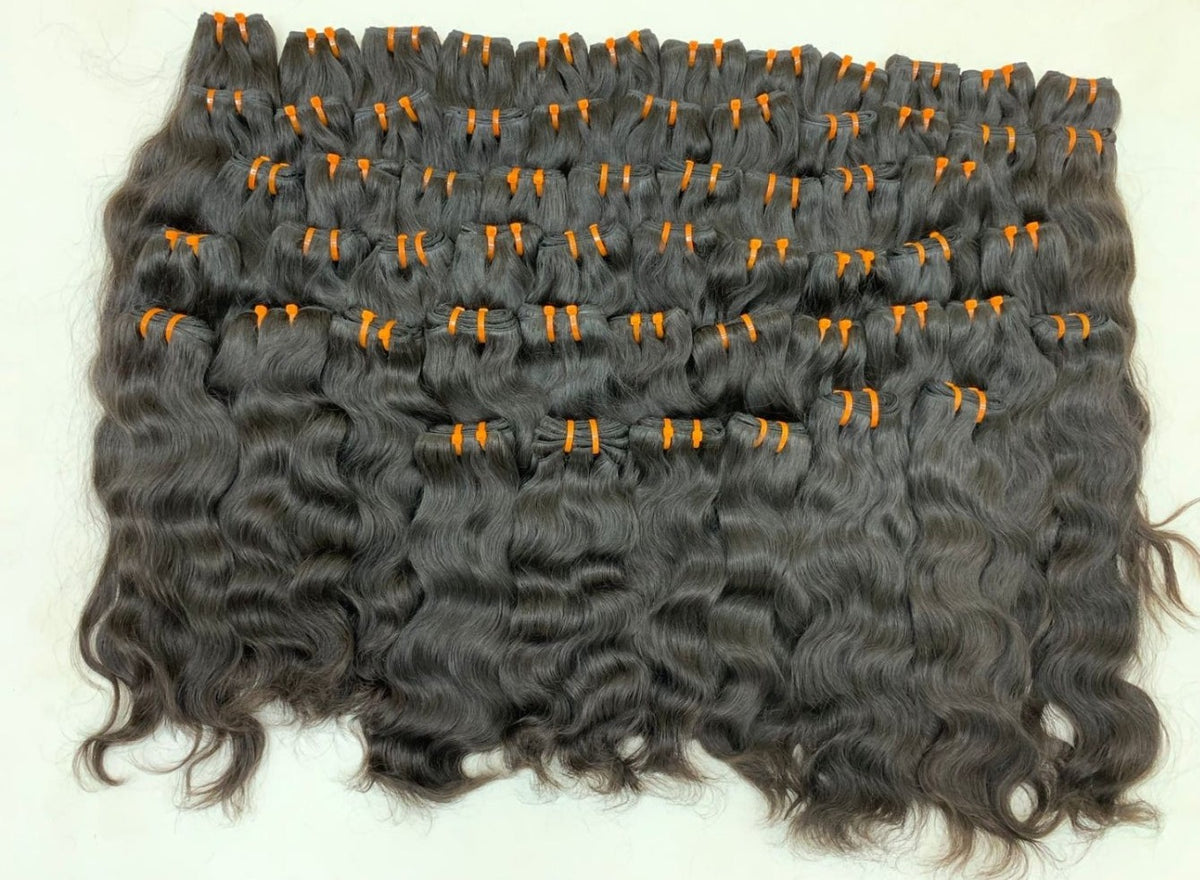 Natural wavy Cambodian raw hair weft bundles laid out, Chandra Hair