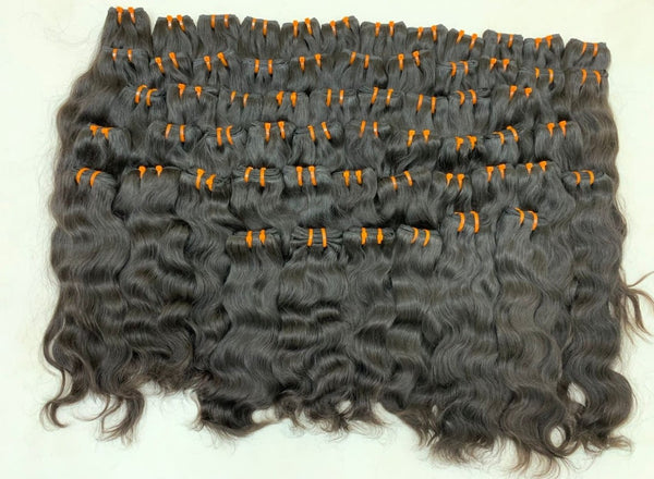 Natural wavy Cambodian raw hair weft bundles laid out, Chandra Hair